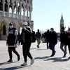 Người dân và du khách đeo khẩu trang phòng lây nhiễm COVID-19 tại Venice, Italy, ngày 8/3. (Ảnh: AFP/TTXVN)