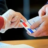 Người dân Pháp đeo găng tay phòng COVID-19 đi bỏ phiếu. (Nguồn: AP)