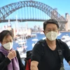 Hành khách đeo khẩu trang phòng lây nhiễm COVID-19 tại sân bay ở Sydney, Australia. (Ảnh: AFP/TTXVN)
