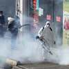 Phun thuốc khử trùng nhằm ngăn chặn sự lây lan của dịch COVID-19 tại Tehran, Iran. (Ảnh: AFP/TTXVN)