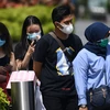 Người dân đeo khẩu trang phòng dịch COVID-2 tại Singapore. (Ảnh: AFP/TTXVN)