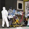 Nhân viên y tế chuyển bệnh nhân mắc COVID-19 từ xe cứu thương vào một bệnh viện ở Dresden, Đức. (Ảnh: AFP/TTXVN)