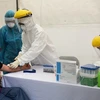 Lấy mẫu xét nghiệm virus SARS-CoV-2 cho người dân tại trạm xét nghiệm nhanh quận Ba Đình. (Ảnh: TTXVN phát)