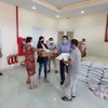 Bà con người Campuchia gốc Việt có hoàn cảnh đặc biệt khó khăn trên địa bàn tỉnh Preah Sihanouk nhận quà hỗ trợ do Tổng Lãnh sự quán Việt Nam quyên góp. (Ảnh: Vũ Hùng/TTXVN)