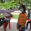 Kiểm tra thân nhiệt các lao động nhập cư nhằm ngăn chặn sự lây lan của dịch COVID-19 tại Phnom Penh, Campuchia. (Ảnh: AFP/TTXVN)