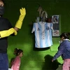 Chiếc áo có chữ ký của huyền thoại Diego Maradona được trưng bày tại một quán ăn cộng đồng ở Buenos Aires. (Nguồn: AFP)