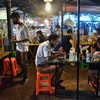 Một quán ăn tại Bangkok, Thái Lan, sử dụng tấm chắn nhựa trên bàn ăn để ngăn chặn sự lây lan của COVID-19. (Ảnh: AFP/TTXVN)