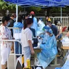 Nhân viên y tế lấy mẫu dịch xét nghiệm COVID-19 cho người dân ở Bắc Kinh, Trung Quốc ngày 26/6. (Ảnh: THX/TTXVN)