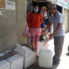 Người dân thôn Từ Tâm 1 (xã Phước Hải, huyện Ninh Phước) phải đi mua nước để về sử dụng trong mùa khô hạn 2020. (Ảnh: Nguyễn Thành/TTXVN)