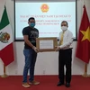 Đại sứ Việt Nam tại Mexico Nguyễn Hoài Dương (phải) trao tặng thiết bị y tế phòng dịch cho đại diện Viện Hữu nghị Mexico Việt Nam. (Ảnh: Lưu Việt Hùng/TTXVN)
