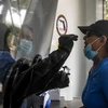 Nhân viên y tế lấy mẫu dịch xét nghiệm COVID-19 cho người dân tại Miami Beach, bang Florida, Mỹ. (Ảnh: AFP/TTXVN)
