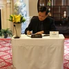 Đại sứ Việt Nam tại Hoa Kỳ Hà Kim Ngọc ký sổ tang. Ảnh: CQTT Washington DC. (Ảnh: TTXVN)