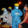Nhân viên y tế đang lấy mẫu xét nghiệm của người dân tại cảng cá Thọ Quang (Đà Nẵng). (Ảnh: Văn Dũng/TTXVN)