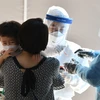 Nhân viên y tế lấy mẫu xét nghiệm COVID-19 cho người dân tại Seoul, Hàn Quốc ngày 18/8. (Ảnh: AFP/TTXVN)