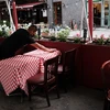 Nhân viên sửa soạn lại bàn ghế tại một nhà hàng ở New York, Mỹ. (Ảnh: AFP/TTXVN)