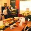Đại sứ Thái Xuân Dũng (phải) tặng hoa chúc mừng cơ quan thường trú TTXVN tại Praha. (Ảnh: Bích Ngọc/Vietnam+)