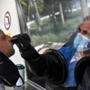 Nhân viên y tế lấy mẫu dịch xét nghiệm COVID-19 cho người dân tại Miami, Mỹ. (Ảnh: AFP/TTXVN)