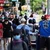 Người dân đeo khẩu trang phòng COVID-19 khi di chuyển trên đường phố tại New York, Mỹ. (Ảnh: AFP/TTXVN)