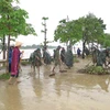 Các lực lượng dọn dẹp bùn đất tại khu vực 2 bên bờ sông Hương. (Ảnh: Tường Vi/TTXVN)