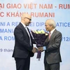 Chủ tịch Hội Hữu nghị Việt Nam-Romania Tống Văn Nga tặng hoa, chúc mừng 102 năm Quốc khánh Romania. (Ảnh: Văn Điệp - TTXVN)