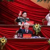 Tổng Bí thư, Chủ tịch nước Nguyễn Phú Trọng và các thành viên Đoàn Chủ tịch biểu quyết thông qua danh sách Ban Thẩm tra tư cách đại biểu. (Ảnh: TTXVN)