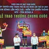 Chủ tịch UBND Thành phố Hồ Chí Minh Nguyễn Thành Phong cùng đại diện Ban tổ chức trao chiếc áo vàng chung cuộc cho vận động viên Loic Desriac. (Ảnh: Thanh Vũ/TTXVN)