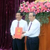 Phó Trưởng Ban Tổ chức Trung ương Hoàng Đăng Quang (phải) trao Quyết định chuẩn y ông Bùi Văn Nghiêm giữ chức Bí thư Tỉnh ủy Vĩnh Long nhiệm kỳ 2020-2025. (Ảnh: Phạm Minh Tuấn/TTXVN)