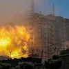 Khói lửa bốc lên từ Toà tháp Jala, nơi đặt văn phòng một số hãng truyền thông quốc tế, khi tòa nhà này bị trúng không kích của Israel tại Dải Gaza. (Ảnh: AFP/TTXVN)
