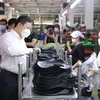 Phó Chủ tịch Dương Anh Đức thăm hỏi công nhân tại các chuyền sản xuất của Công ty trách nhiệm hữu hạn Pouyuen Việt Nam (quận Bình Tân). (Ảnh: Thanh Vũ/TTXVN)