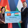 Phó Quốc vụ khanh Bộ Ngoại giao và Kinh tế Đối ngoại István Joó trao tặng cho Đại sứ Việt Nam Nguyễn Thị Bích Thảo. (Ảnh: TTXVN phát)