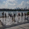Trẻ em chơi đùa dưới vòi phun nước để tránh nóng tại New York, Mỹ, ngày 30/6/2021. (Ảnh: AFP/TTXVN)