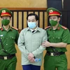 Lực lượng chức năng dẫn giải bị cáo Phan Văn Anh Vũ đến phiên tòa xét xử. (Ảnh: Phạm Kiên/TTXVN)