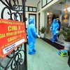 Nhân viên y tế ghi thông tin trường hợp F0 đang điều trị tại nhà tại Xóm 2, xã Tam Hiệp, huyện Thanh Trì. (Ảnh: Tuấn Anh/TTXVN)