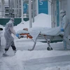 Nhân viên y tế chuyển bệnh nhân COVID-19 tới bệnh viện ở Kommunarka, Nga. (Ảnh: THX/TTXVN)