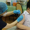 Nhân viên y tế tiêm vaccine phòng COVID-19 cho học sinh trường Trung học cơ sở Hồng Bàng (Quận 5). (Ảnh: Thu Hương/TTXVN)