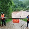 Lực lượng Bộ đội Biên phòng cắm biển báo nguy hiểm, chốt chặn, tuyên truyền, hướng dẫn, nhắc nhở người dân và phương tiện không đi qua vùng nguy hiểm. (Ảnh: TTXVN phát)