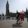 Người dân di chuyển dưới trời nắng gắt tại London, Anh ngày 6/9/2023. (Ảnh: AFP/TTXVN)