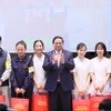 Thủ tướng Phạm Minh Chính tặng quà cho đại diện thực tập sinh và người lao động đang làm việc tại Nhật Bản. (Ảnh: Dương Giang/TTXVN)