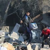 Người dân nhặt nhạnh đồ đạc còn sót lại trong đống đổ nát sau vụ không kích của Israel xuống trại tị nạn Al-Maghazi ở Dải Gaza. (Ảnh: THX/TTXVN)