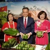 Đại sứ Việt Nam tại Liên bang Nga Đặng Minh Khôi (giữa) và Phu nhân (thứ 2, phải qua) cùng bà con cộng đồng gói bánh chưng. (Ảnh: TTXVN)
