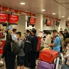 Hành khách làm thủ tục hàng không tại sân bay Tân Sơn Nhất. (Ảnh: Quang Châu/TTXVN)