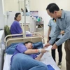 Lãnh đạo Ủy ban Nhân dân thị xã Quảng Yên thăm hỏi các công nhân đang được theo dõi tại bệnh viện. (Ảnh: TTXVN phát)