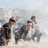 Người dân và du khách cùng hòa vào suối Nậm Mu tham gia Lễ hội té nước. (Ảnh: Nguyễn Oanh/TTXVN)