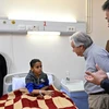 Tổng thư ký LHQ Antonio Guterres thăm hỏi một bệnh nhi từ Dải Gaza được sơ tán sang bệnh viện ở El-Arish, Ai Cập để điều trị, ngày 23/3. (Ảnh: AFP/TTXVN)