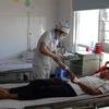 Bác sỹ Bệnh viện Đa khoa Tâm Trí Nha Trang chăm sóc sức khỏe cho bệnh nhân nghi ngộ độc thực phẩm sau khi ăn sáng 5/4. (Ảnh: Phan Sáu/TTXVN)