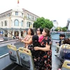 Du khách hào hứng khi được tham quan Hà Nội bằng xe buýt 2 tầng. (Ảnh: Tuấn Anh/TTXVN)