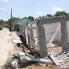 Một căn nhà của người dân ở thị trấn Ngan Dừa (Hồng Dân, Bạc Liêu) bị sụt xuống sông do ảnh hưởng của hạn hán. (Ảnh: Chanh Đa/TTXVN)