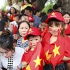 Những em nhỏ với trang phục rực rỡ cờ hoa theo người lớn đi xem diễu binh, diễu hành. (Ảnh: Xuân Tư/TTXVN)