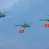 Phần trình diễn của trực thăng mang cờ Đảng, cờ Tổ quốc tại Lễ kỷ niệm 70 năm Chiến thắng Điện Biên Phủ. (Ảnh: Dương Giang/TTXVN)