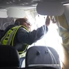 Điều tra viên kiểm tra phần cửa sổ bị bung ra của máy bay Boeing 737 MAX 9 thuộc hãng hàng không Alaska Airlines. (Ảnh: AFP/TTXVN)